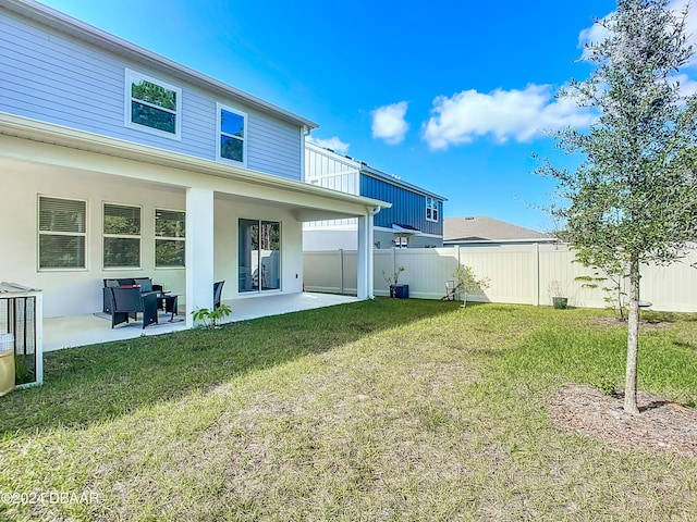 back of house with a lawn and a patio area