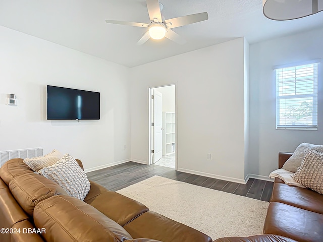 living room featuring ceiling fan and dark hardwood / wood-style floors