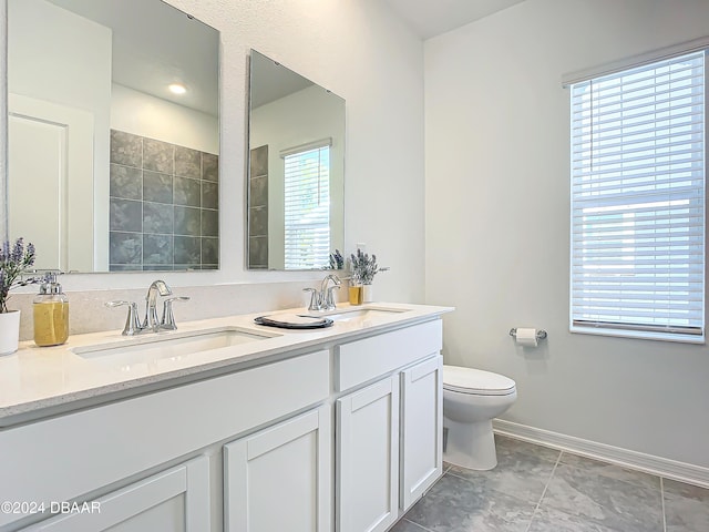 bathroom with tile patterned flooring, vanity, and toilet