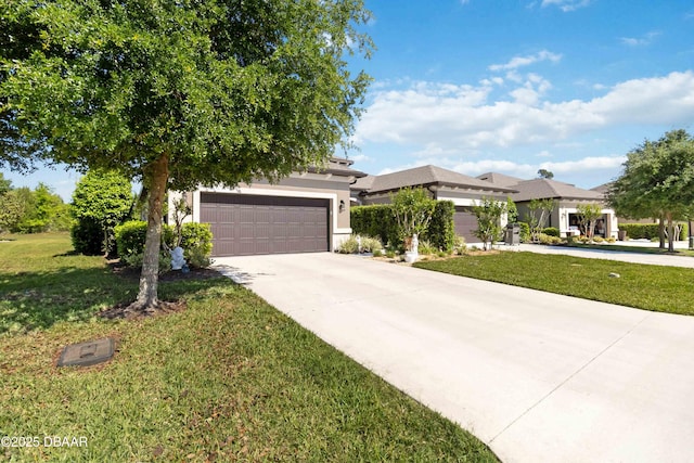 view of front of house with stucco siding, a garage, a front yard, and concrete driveway