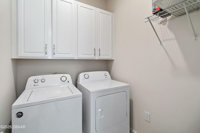 clothes washing area featuring washer and clothes dryer and cabinet space
