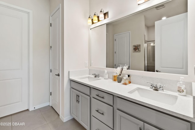 full bathroom with double vanity, a shower stall, tile patterned flooring, and a sink