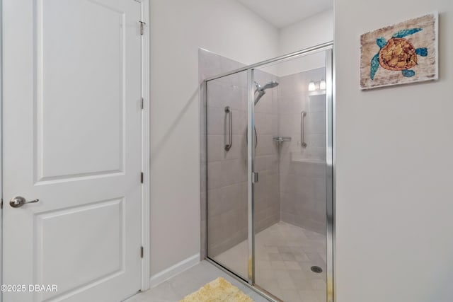 bathroom featuring a shower stall, tile patterned floors, and baseboards