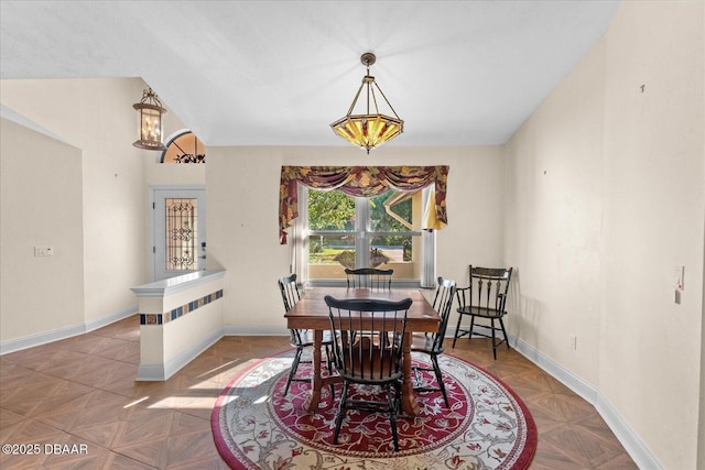 dining room featuring baseboards and a notable chandelier