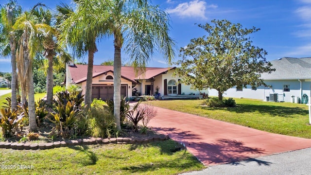 view of front of home featuring central AC unit, a front lawn, stucco siding, concrete driveway, and a garage