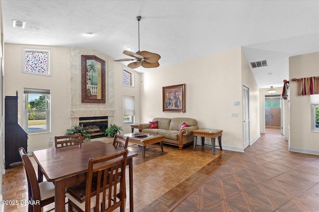 dining room with baseboards, a ceiling fan, visible vents, and a premium fireplace