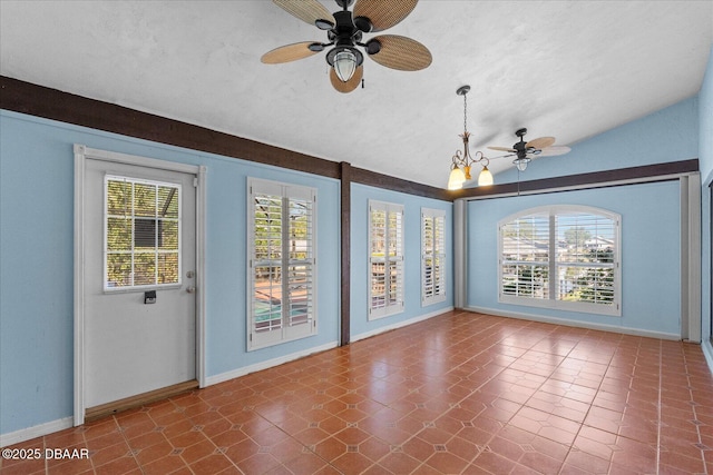 interior space featuring plenty of natural light, lofted ceiling, baseboards, and ceiling fan with notable chandelier