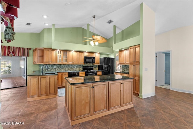 kitchen with a ceiling fan, a sink, brown cabinetry, black appliances, and visible vents