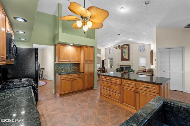 kitchen featuring brown cabinetry, black microwave, a ceiling fan, and lofted ceiling