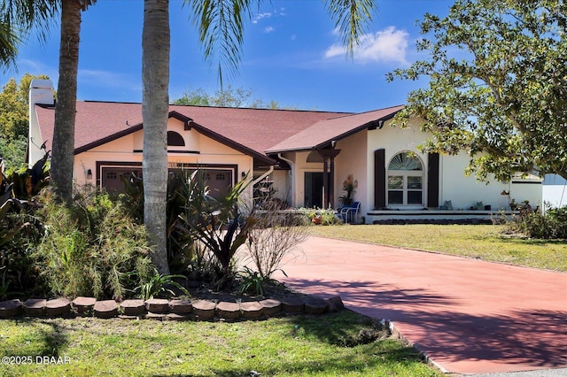 view of front of house featuring a shingled roof, a front lawn, stucco siding, an attached garage, and driveway