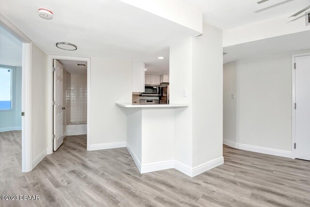 2625 S Atlantic Ave Unit 7Nw, Daytona Beach Shores, FL 32118 - kitchen with stainless steel microwave, light countertops, light wood-type flooring, fridge, and recessed lighting