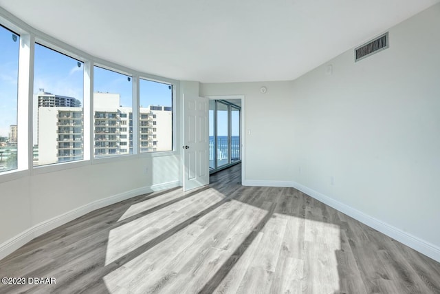 2625 S Atlantic Ave Unit 7Nw, Daytona Beach Shores, FL 32118 - empty room featuring wood finished floors, baseboards, and a view of city