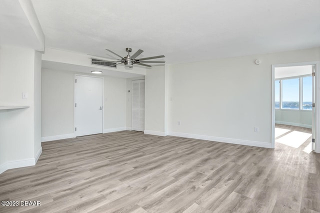 unfurnished room featuring light hardwood / wood-style flooring, a water view, and ceiling fan