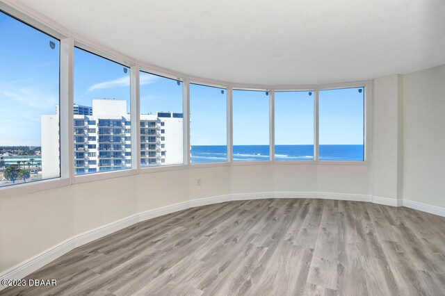 2625 S Atlantic Ave Unit 7Nw, Daytona Beach Shores, FL 32118 - spare room with wood finished floors, a water view, baseboards, and plenty of natural light