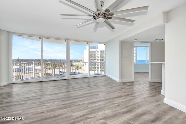 2625 S Atlantic Ave Unit 7Nw, Daytona Beach Shores, FL 32118 - unfurnished living room with ceiling fan, wood finished floors, baseboards, and a view of city