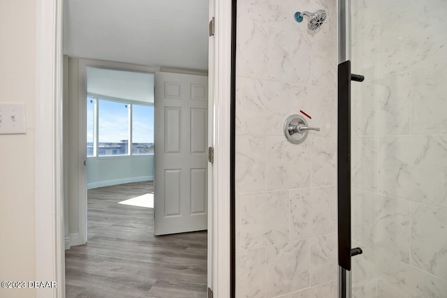 bathroom featuring hardwood / wood-style flooring and a tile shower