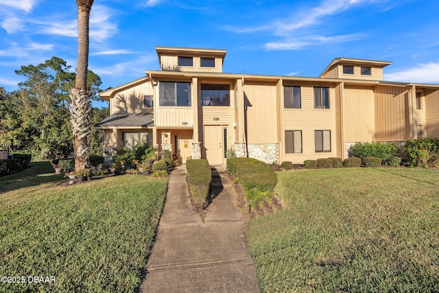 view of property with a front yard and stone siding