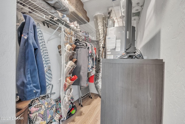 walk in closet with wood finished floors