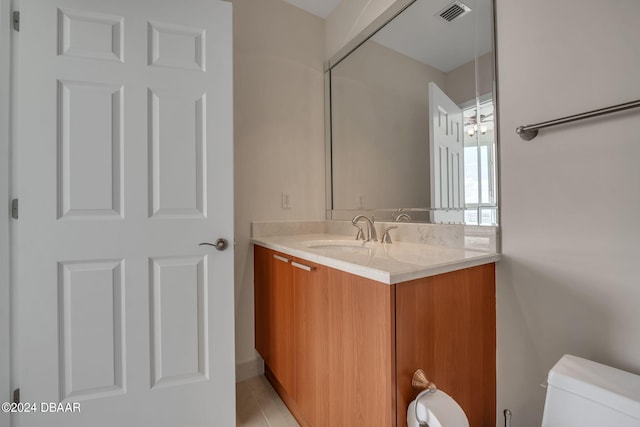 bathroom with tile patterned flooring, vanity, and toilet