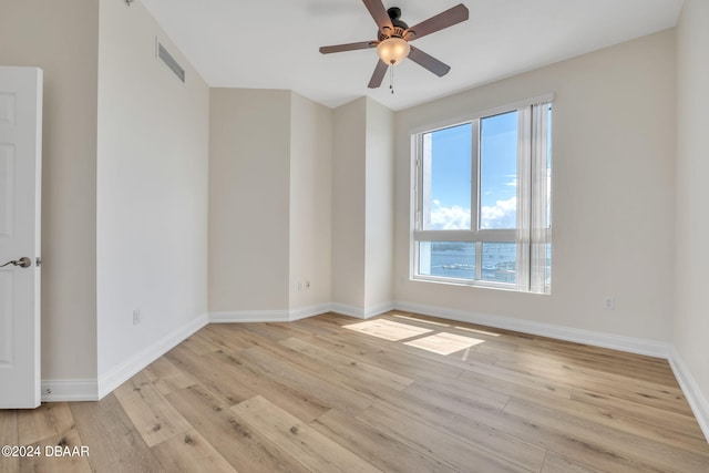 empty room with light wood-type flooring and ceiling fan