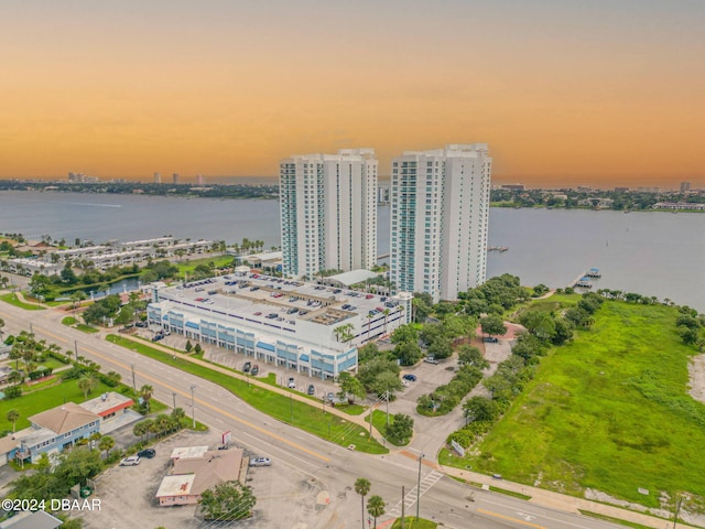 aerial view at dusk featuring a water view