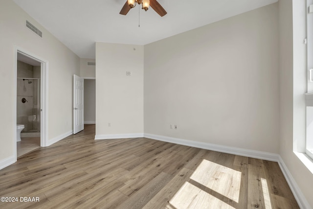 unfurnished bedroom featuring light hardwood / wood-style floors, ceiling fan, and ensuite bath