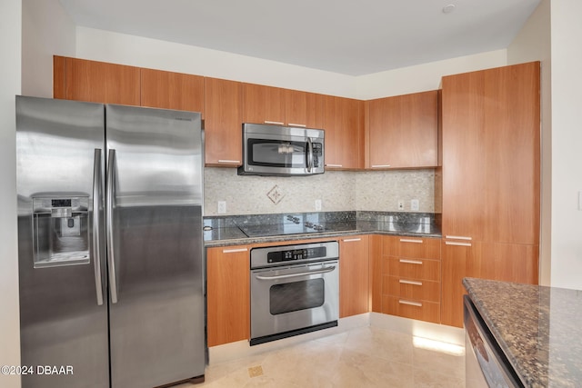 kitchen with light tile patterned floors, backsplash, and appliances with stainless steel finishes