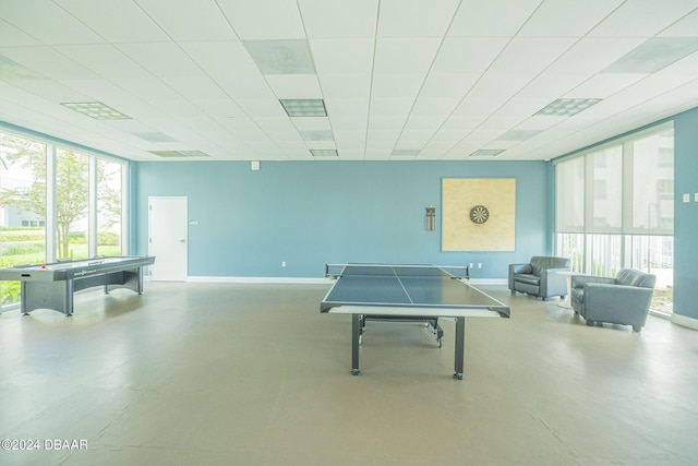 playroom featuring concrete flooring and a paneled ceiling