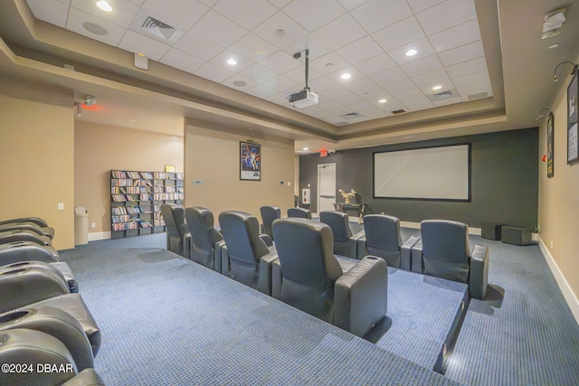 cinema room featuring carpet floors and a raised ceiling