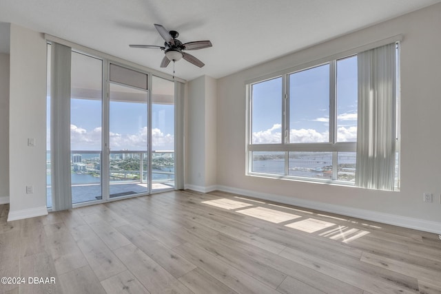 unfurnished room featuring light hardwood / wood-style floors, a healthy amount of sunlight, and ceiling fan