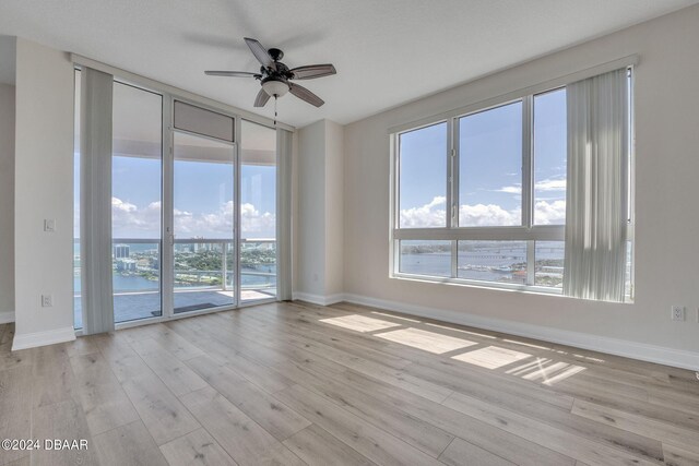 231 Riverside Dr Unit 2601-1, Daytona Beach, FL 32117 - unfurnished room featuring healthy amount of natural light, ceiling fan, baseboards, and wood finished floors