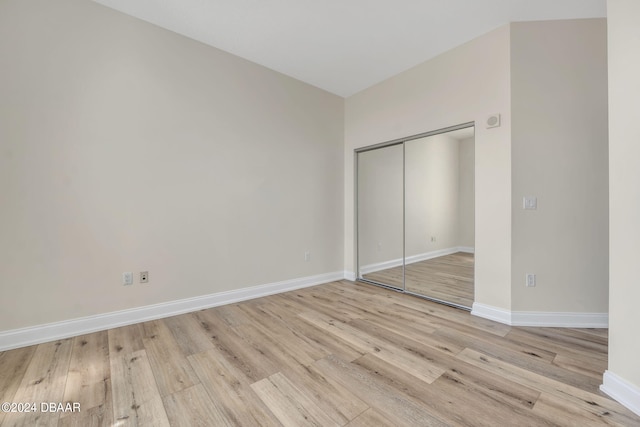 unfurnished bedroom featuring a closet and light hardwood / wood-style flooring