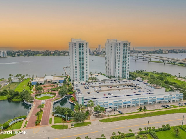 aerial view at dusk featuring a water view