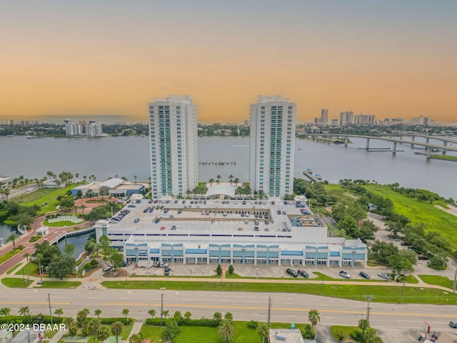 aerial view at dusk featuring a water view