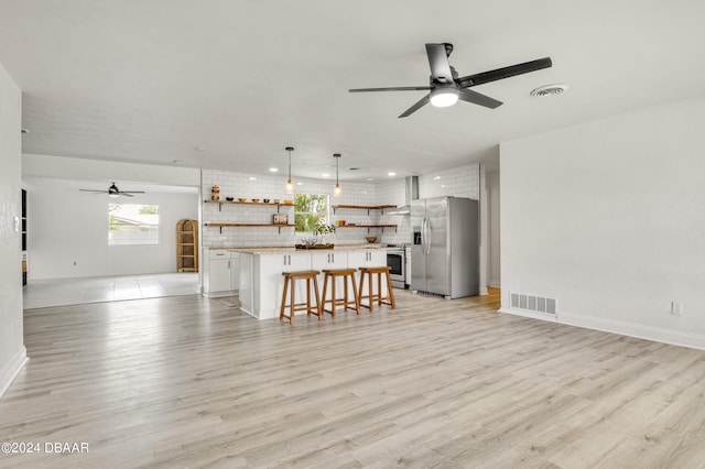 unfurnished living room featuring ceiling fan and light hardwood / wood-style flooring