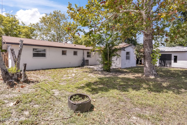 1703 Hill St, Edgewater, FL 32132 - rear view of house featuring central AC unit and a lawn