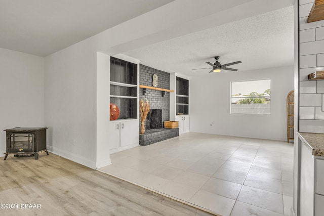 1703 Hill St, Edgewater, FL 32132 - unfurnished living room with a textured ceiling, a fireplace, light hardwood / wood-style floors, and ceiling fan