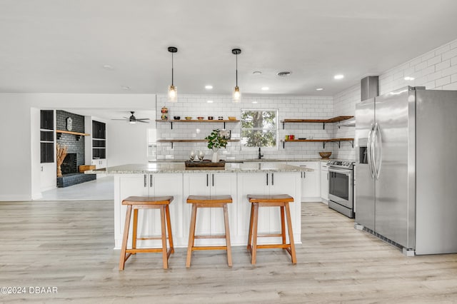 1703 Hill St, Edgewater, FL 32132 - kitchen featuring white cabinetry, stainless steel appliances, hanging light fixtures, and light hardwood / wood-style floors