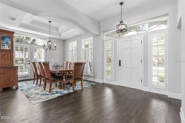 foyer featuring a chandelier, a raised ceiling, and dark wood-type flooring