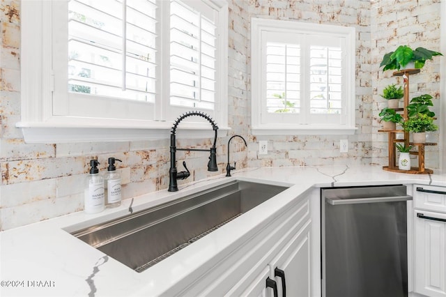 kitchen featuring dishwasher, white cabinets, a healthy amount of sunlight, and sink