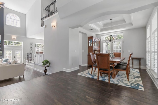 dining area featuring an inviting chandelier, dark wood-type flooring, a wealth of natural light, and a tray ceiling