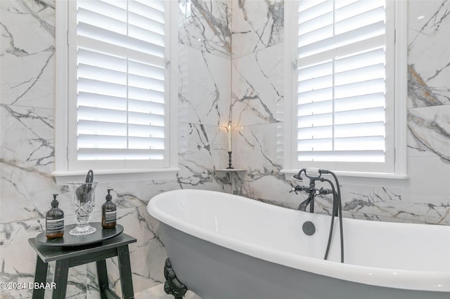 bathroom featuring a bath and tile walls