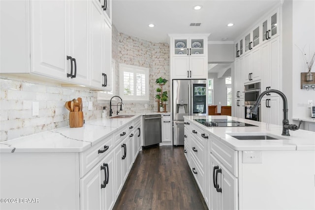 kitchen with white cabinetry, sink, light stone counters, and appliances with stainless steel finishes