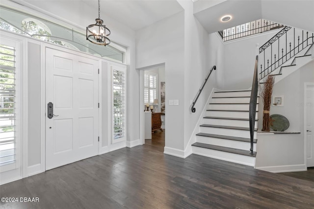 entryway featuring dark wood-type flooring and an inviting chandelier