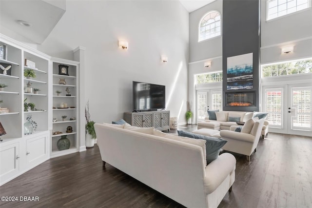 living room featuring dark hardwood / wood-style floors, built in features, and a high ceiling