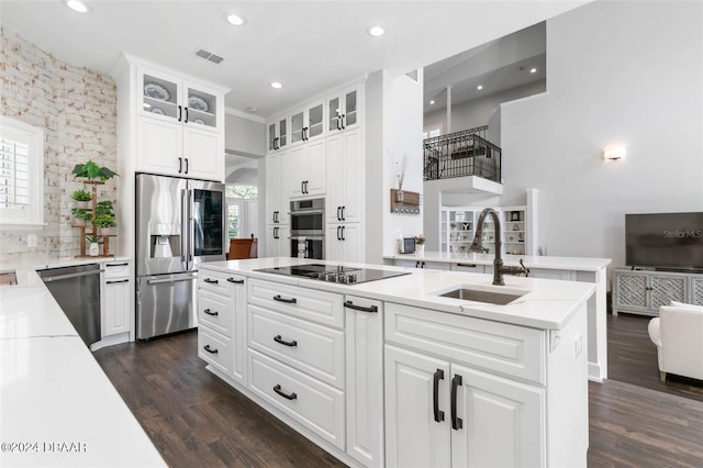 kitchen featuring light stone countertops, appliances with stainless steel finishes, dark wood-type flooring, sink, and white cabinetry