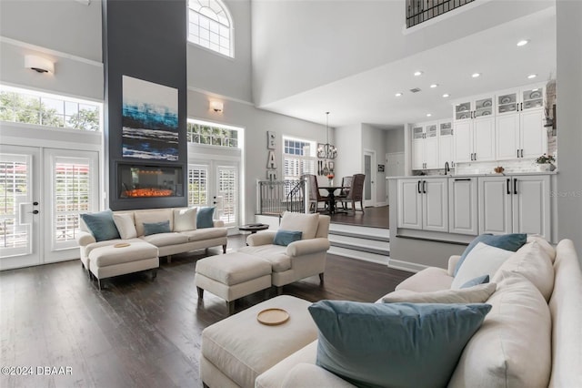 living room featuring sink, dark hardwood / wood-style flooring, a fireplace, and a high ceiling