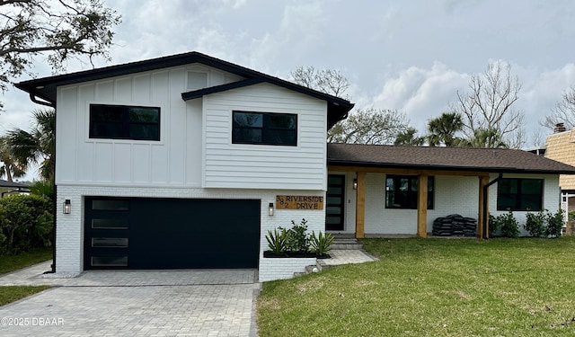 view of front of property featuring brick siding, board and batten siding, a front lawn, decorative driveway, and an attached garage