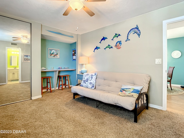 living area with ceiling fan and carpet floors