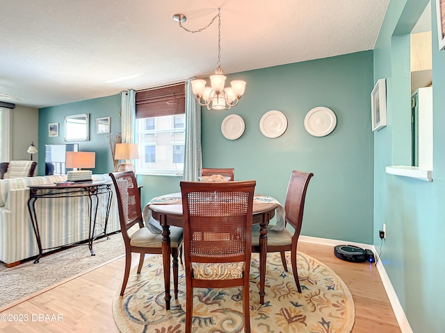 dining room with light hardwood / wood-style floors and an inviting chandelier